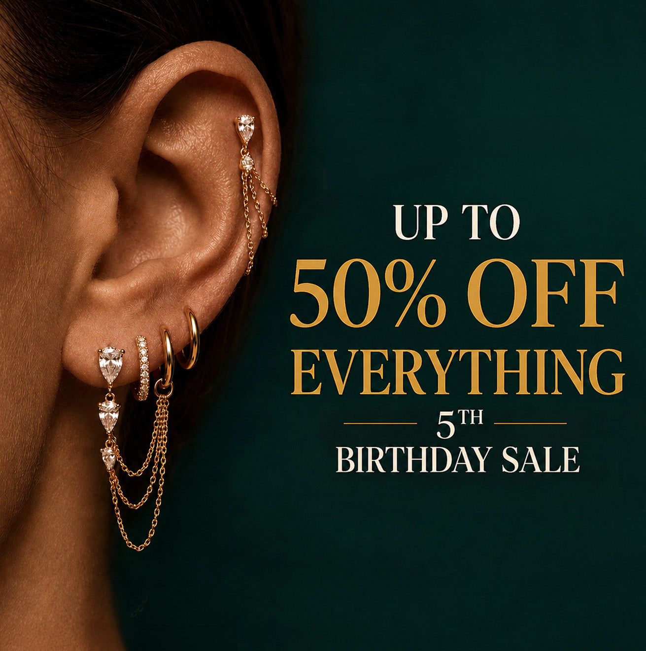 IMBER 5th Birthday Sale ad featuring a gold waterproof implant grade titanium earring stack with crystal studs, huggies, chain details, and text reading up to 50% off everything